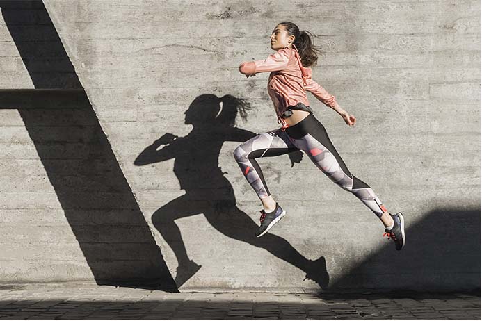 mulher praticando corrida de rua com muita energia