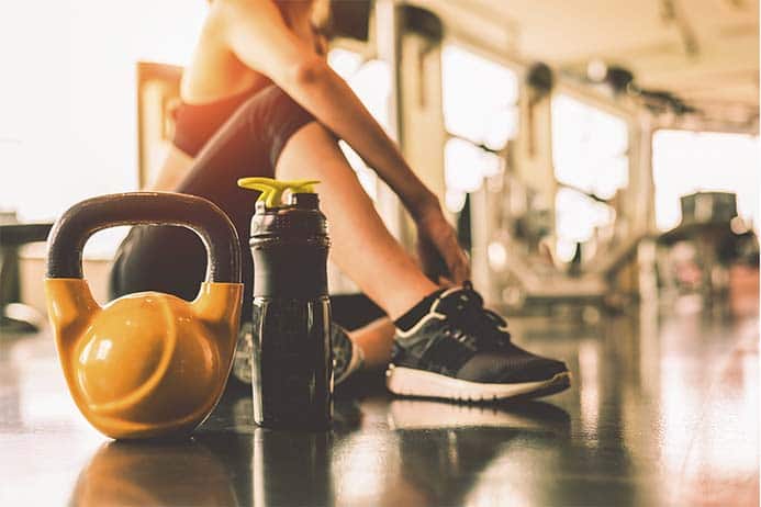 garota descansando na sala de musculação