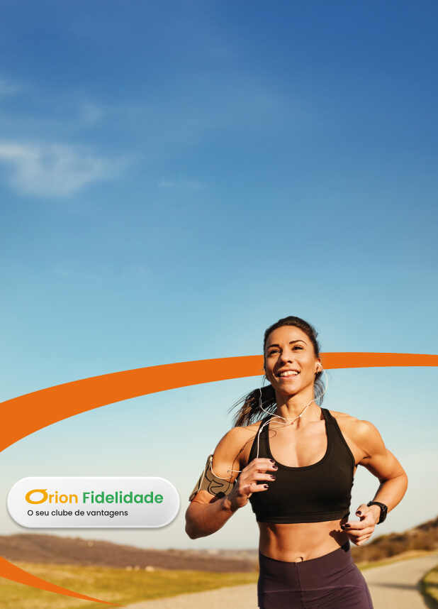 Mulher feliz e ativa correndo ao ar livre sob o sol, usando fones de ouvido e armband, simbolizando saúde, bem-estar e os benefícios do programa Orion Fidelidade - O seu clube de vantagens da Órion Farmácia de Manipulação.