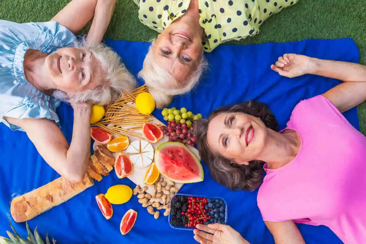 Uma variedade de frutas frescas e coloridas, vegetais e nozes, representando as fontes naturais de vitaminas e minerais essenciais, ao lado de suplementos em cápsulas e comprimidos da Órion Farmácia de Manipulação, ilustrando a importância da nutrição para a saúde e bem-estar
