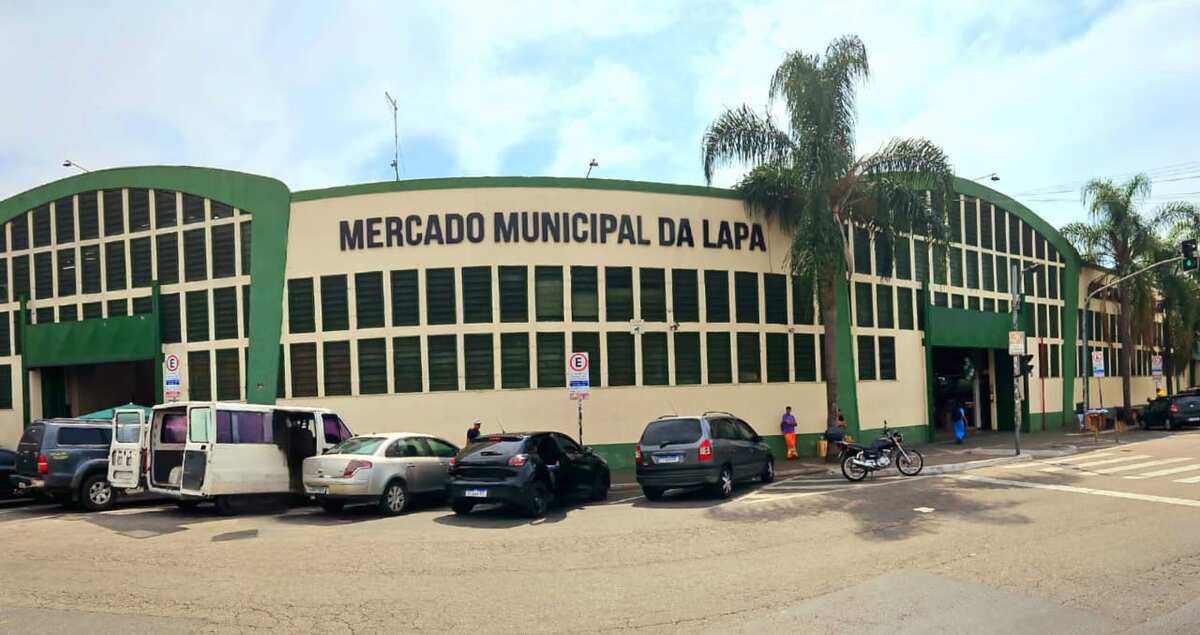 Rua movimentada no bairro da Lapa, em São Paulo, com edifícios de arquitetura variada, transeuntes e veículos, refletindo a energia e o cotidiano da região. A imagem contextualiza a localização da Órion Farmácia de Manipulação na Lapa, destacando sua acessibilidade e integração à comunidade local para oferecer soluções de saúde e bem-estar